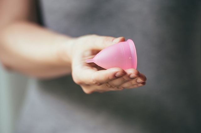 Young woman hand holding menstrual cup