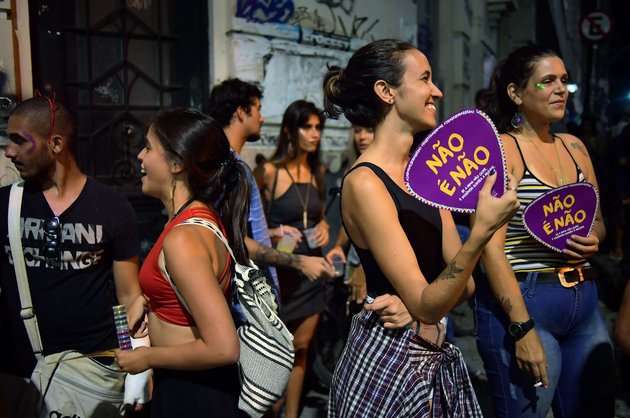 Revellers at a street party hold fans which read "Nao e Nao" or "No Means No" at a street party during carnival season in Rio de Janeiro on February 7, 2018. Brazilian activists have taken to distributing temporary tattoos and visual slogans to raise awareness about sexual harassment during carnival. Often, consumption of alcohol and revealing outfits worn by women are used as an excuse by sexual predators during this world-famous festive event. / AFP PHOTO / CARL DE SOUZA        (Photo credit should read CARL DE SOUZA/AFP/Getty Images)